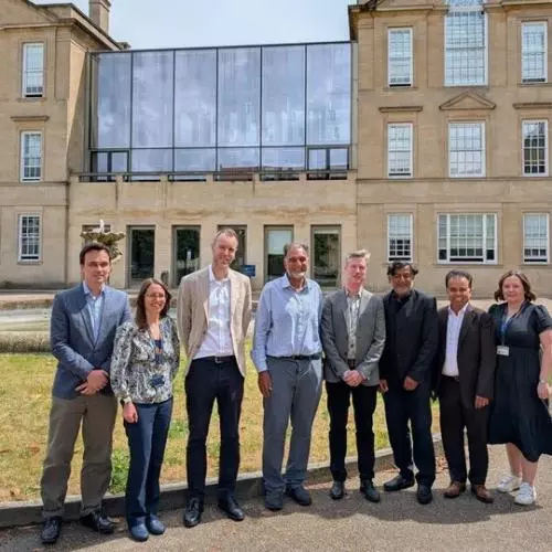 A group of eight people stand in front of a building. 